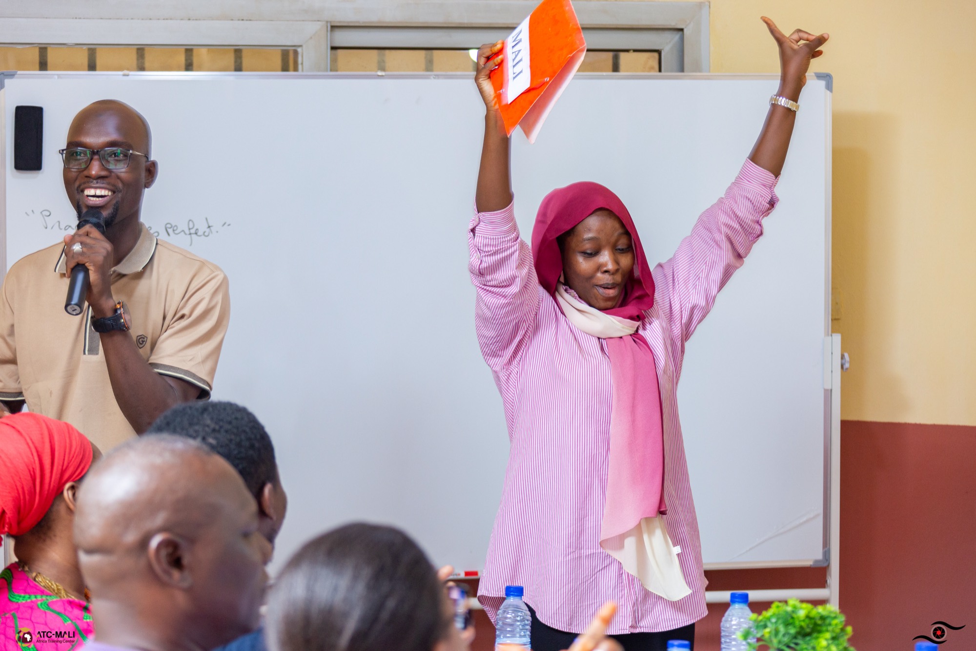 Apprenante d’ATC-Mali levant les bras pendant un atelier d’anglais pratique